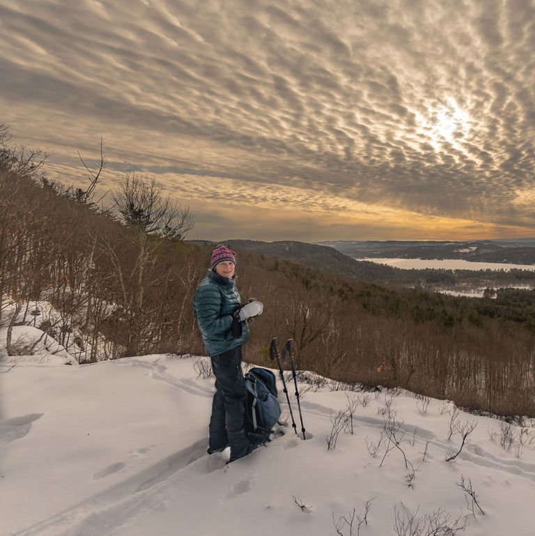 snowshoer enjoying view atop hill