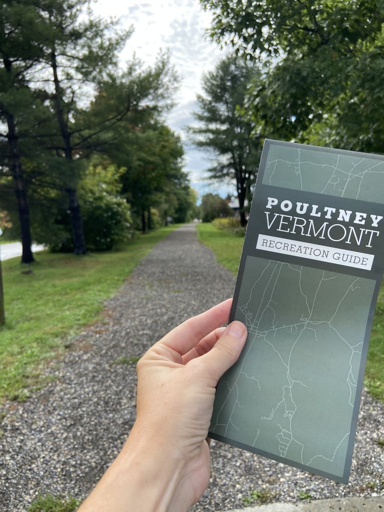 Person holding the Poultney Recreation brochure next to the D&H Rail Trail
